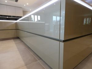 grey gloss modern kitchen units with lighting underneath the counter top